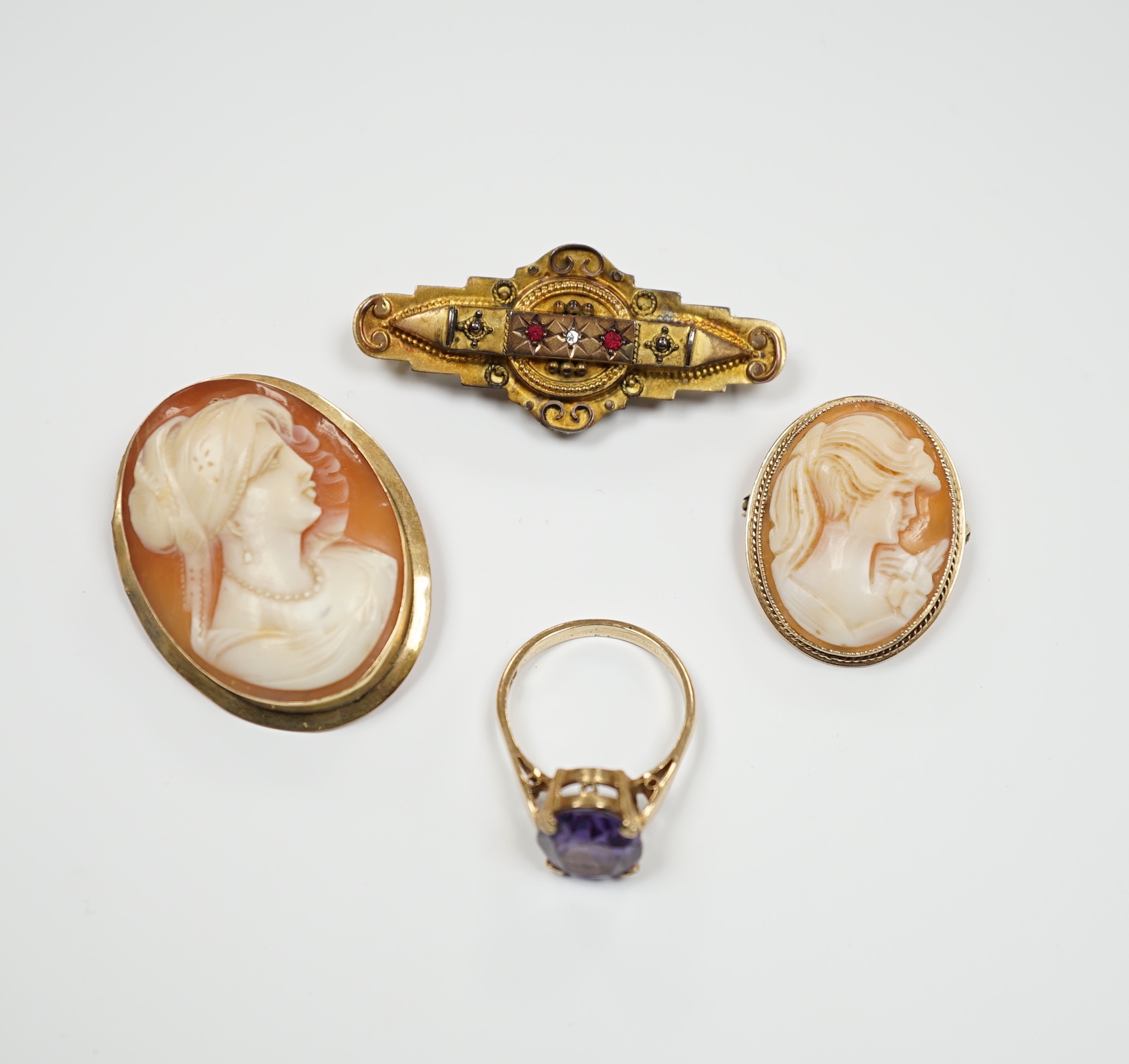 Two 9ct mounted oval cameo shell brooches, largest 38mm, a 9ct and gem set ring and a 9ct gold and gem set bar brooch.